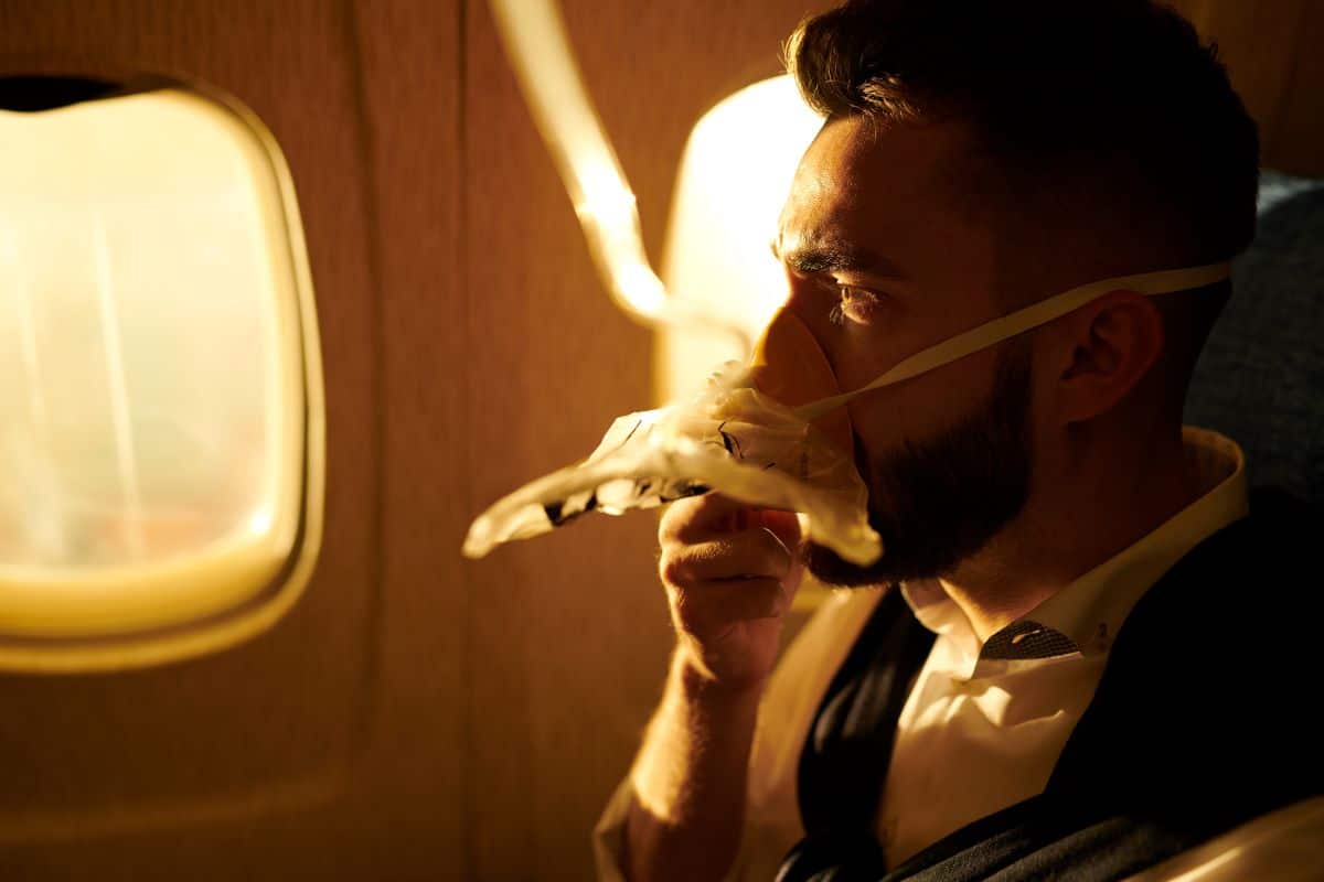 Man wearing an oxygen mask on a flight